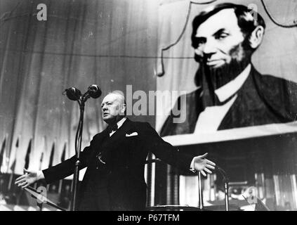 Photo de Winston Churchill (1874-1965), parlant à l'Albert Hall devant une grande photo d'Abraham Lincoln (1809-1865). Datée 1944 Banque D'Images