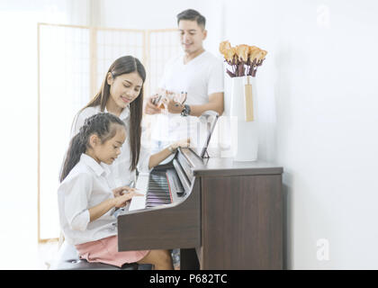 La famille asiatique, la mère et la fille joue du piano,père jouer de la guitare dans family band à la maison, concept de relation familiale Banque D'Images