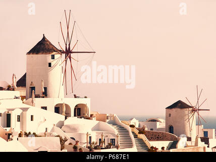 Beau paysage classique avec des bâtiments blancs vintage et moulins à vent à Oia sur l'île de Santorin, Grèce au coucher du soleil Banque D'Images