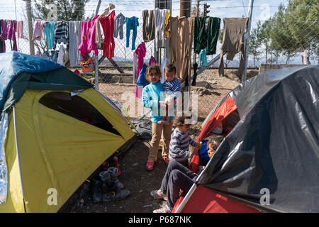 Les enfants réfugiés d'un côté de tentes utilisées comme un refuge dans un camp de fortune à la gare de l'Greek-Macedonian frontière près du village grec de Id Banque D'Images