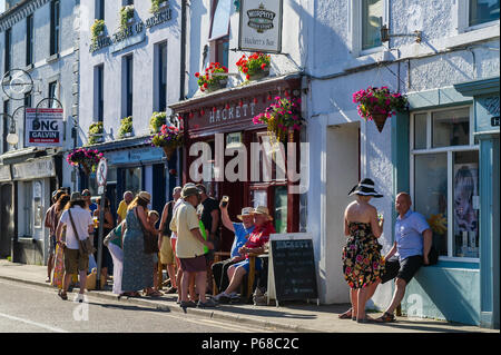 Schull, West Cork, Irlande. 28 Juin, 2018. Les habitants et les touristes prendre un verre au bar de l'Hackett sur Schull rue principale. Les températures vont rester dans le haut entre 20 Celsius demain mais pluies sont prévues au cours de la fin de semaine. Credit : Andy Gibson/Alamy Live News. Banque D'Images