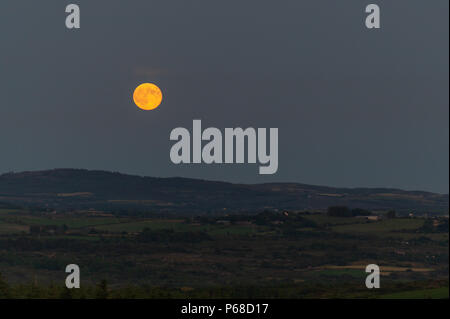 West Cork, Irlande. 28th juin 2018. Une spectaculaire pleine lune apparaît à l'horizon au-dessus de West Cork après une journée de températures record. Certaines parties de l'Irlande ont atteint le début des 30°C. Les températures élevées devraient se poursuivre demain avant de laisser place à la pluie pendant le week-end. Crédit : AG News/Alay Live News. Banque D'Images