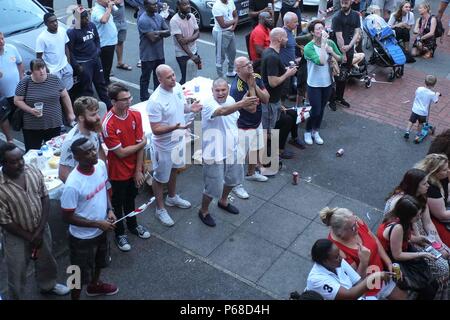 Londres, Royaume-Uni. 28 Juin 2018 : Angleterre football fans sur la réaction à une succession Kirby occasion manquée contre la Belgique. La succession de Bermondsey a été décoré de plus de 300 drapeaux de l'Angleterre. D'autres drapeaux de pays à jouer la Coupe du monde sont également suspendu à un balcon. Crédit : Claire Doherty/Alamy Live News Banque D'Images