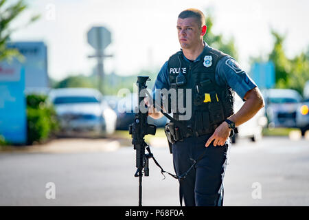 Annapolis, Maryland, USA. 28 Juin, 2018. Un officier de police fonctionne de la scène d'un tournage à la capitale, national building jeudi. Au moins cinq personnes ont été tuées et plusieurs autres blessées. Le tireur présumé a été arrêté sur les lieux. Crédit : Michael Jordan/ZUMA/Alamy Fil Live News Banque D'Images