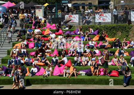 Grenier Square. Londres. Royaume-uni 29 juin 2018 - les travailleurs de la ville et les touristes profiter une autre journée chaude dans le grenier Square, Londres près de Regents Canal assis sur des coussins colorés tout en regardant le Roi Lion film sur un grand écran LED. Selon le Met Office, Juin a été le mois le plus sec jamais enregistré. Credit : Dinendra Haria/Alamy Live News Banque D'Images