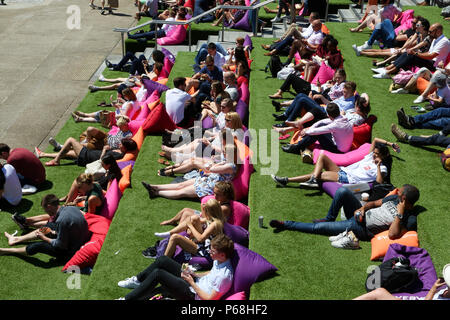 Grenier Square. Londres. Royaume-uni 29 juin 2018 - les travailleurs de la ville et les touristes profiter une autre journée chaude dans le grenier Square, Londres près de Regents Canal assis sur des coussins colorés tout en regardant le Roi Lion film sur un grand écran LED. Selon le Met Office, Juin a été le mois le plus sec jamais enregistré. Credit : Dinendra Haria/Alamy Live News Banque D'Images