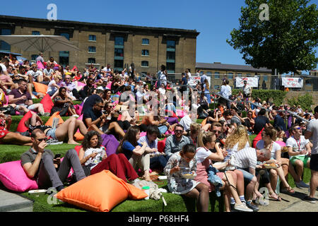 Grenier Square. Londres. Royaume-uni 29 juin 2018 - les travailleurs de la ville et les touristes profiter une autre journée chaude dans le grenier Square, Londres près de Regents Canal assis sur des coussins colorés tout en regardant le Roi Lion film sur un grand écran LED. Selon le Met Office, Juin a été le mois le plus sec jamais enregistré. Credit : Dinendra Haria/Alamy Live News Banque D'Images