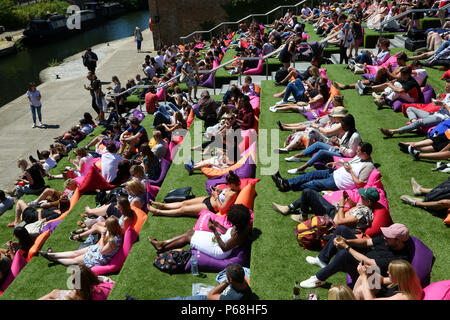 Grenier Square. Londres. Royaume-uni 29 juin 2018 - les travailleurs de la ville et les touristes profiter une autre journée chaude dans le grenier Square, Londres près de Regents Canal assis sur des coussins colorés tout en regardant le Roi Lion film sur un grand écran LED. Selon le Met Office, Juin a été le mois le plus sec jamais enregistré. Credit : Dinendra Haria/Alamy Live News Banque D'Images