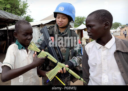 (180629) -- JUBA, 29 juin 2018 (Xinhua) -- des enfants présente un outil d'un fusil à casque bleu chinois Yu Peijie (C) comme un cadeau au No.1 du camp de réfugiés de l'Organisation des Nations Unies, le Soudan du Sud, le 30 avril 2018. Peijie Yu, 26 ans, est le chef de l'unité de soldat de la femelle d'infanterie bataillon de maintien de la paix chinois au Soudan du Sud. Elle a un surnom appelé 'strong frère aîné'. Cependant, elle a aussi un coeur doux. Cette année marque le 70e anniversaire du maintien de la paix des Nations Unies. La Chine a commencé ses participations dans les opérations de maintien de la paix des Nations Unies en 1990. Aujourd'hui, la Chine a quelque 2 500 casques bleus et joue Banque D'Images