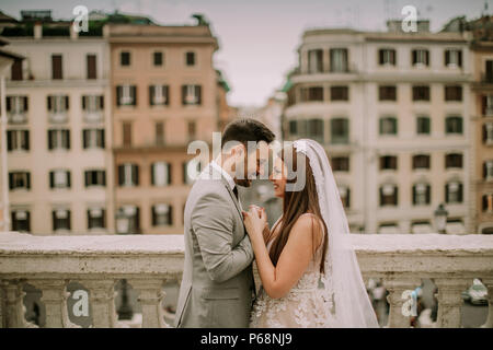 Young attractive couple nouvellement marié posant dans Rome avec belle architecture ancienne et dans l'arrière-plan Banque D'Images