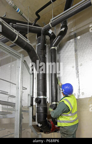La pression d'un ingénieur-tests d'une nouvelle installation de drainage dans le sous-sol d'un nouveau quartier résidentiel de tour à Londres, Royaume-Uni Banque D'Images