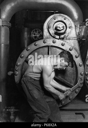 Photographie de mécanicien travaillant sur la pompe à vapeur à la Lewis Hine Power House. Datée 1920 Banque D'Images