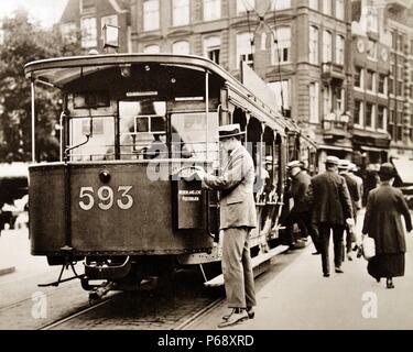 Man poster une lettre dans une boîte de collecte de poste attaché à un tramway à Amsterdam, Pays-Bas 1925 Banque D'Images