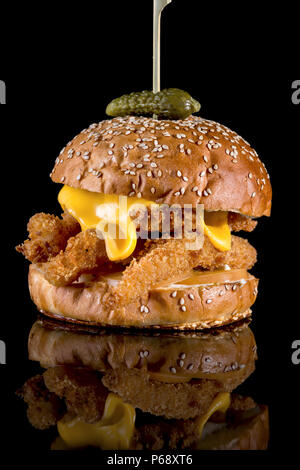 Burger King Fisher - Filets de poisson panés, tranche de fromage américain et sauce tartare avec réflexion isolé sur fond noir Banque D'Images