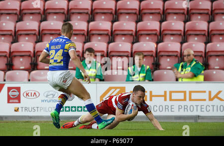 Wigan Warriors Marshall Liam va au-dessus pour un essai passé Leeds Rhinos Jack Walker au cours de la Super League Betfred match à la DW Stadium, Wigan. Banque D'Images