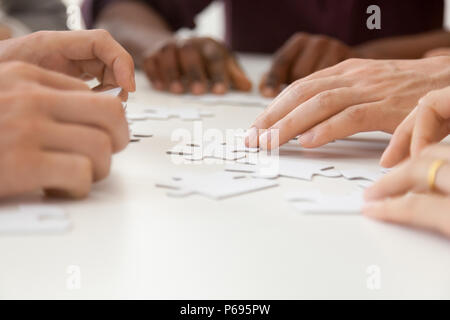 Close up de l'équipe de travail diversifiées de l'assemblage puzzle ensemble Banque D'Images