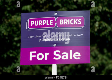 Un purplebricks signe indiquant une propriété est à vendre par l'agence immobilière en ligne. Banque D'Images