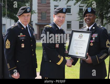 KAISERSLAUTERN, Allemagne - Le Sgt. 1re classe Jomarian Robbins reçoit un certificat du président de Brig. Gen. Arlan DeBlieck, le 21e TSC commandant général adjoint, comme le Sergent Commande TSC Le major Stanley Richards ressemble à la retraite au cours d'une cérémonie tenue le 26 mai au domaine de panzers. Robbins, qui a rejoint l'armée en 1994, a clos une longue carrière d'infirmier de l'Armée de Landstuhl Regional Medical Center. (U.S. Photo de l'armée par le sergent. Betty Boom, 21 TSC Affaires publiques) Banque D'Images