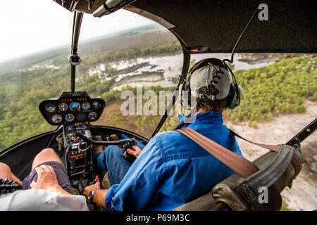 Jock au bâton de contrôle de son hélicoptère Robinson R44 Raven dans le territoire du Nord, en Australie Banque D'Images