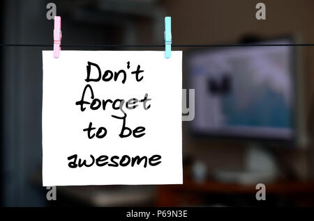 N'oubliez pas d'être impressionnant. La note est écrite sur un autocollant blanc qui se bloque avec un clothespin sur une corde sur un fond d'office interior . Banque D'Images