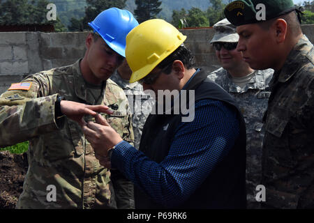 PALO GORDO, Guatemala - U.S. Army Staff Sgt. Shaun rase, gauche, 1038th compagnie du génie gestionnaire de projet, indique le maire de Palo Gordo Juan Carlos Ochoa Arrecis photos d'un tunnel le 31 mai 2016, lors de l'exercice AU-DELÀ DE L'HORIZON 2016 AU GUATEMALA. Soldats trouvés un tunnel qui a été creusé à partir d'une chambre dans le site d'emploi après le Palo Gordo site clinique a été dépouillé de matériau de construction. Banque D'Images