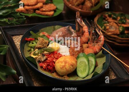 Nasi Jamblang, le plat de riz Signature de Cirebon, West Java. Riz vapeur en feuille de teck parcelle servi avec beaucoup de plats d'accompagnement. Banque D'Images