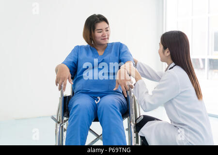 Asian Woman Doctor talking to young pregnant woman en fauteuil roulant à l'hôpital. Belle asiatique médecin prendre soin des patients en fauteuil roulant. Banque D'Images