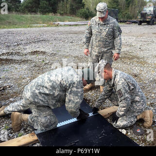 Fort Drum, N.Y. -- SPC. Dylan Preston (à gauche), Sgt. Timothy Bunzey, Jr. (centre) et la FPC. Peter Skelly (droite) de la Garde Nationale de New York's 204e détachement du génie (carrière) mesurer et couper une nouvelle courroie de transport pour remplacer une courroie à défaut d'une carrière sur une machine appelée "crusher" ici le 14 mai. Le concasseur d'exploitation, qui peut tourner de grosses roches dans différentes catégories de matériaux de construction, est la mission principale du détachement. Soldats du détachement, qui est basé à Binghamton, N.Y., a travaillé pendant environ 10 heures le 14 mai pour corriger plusieurs lacunes mécaniques et assurer l'aplatisseur est le pupitre Banque D'Images