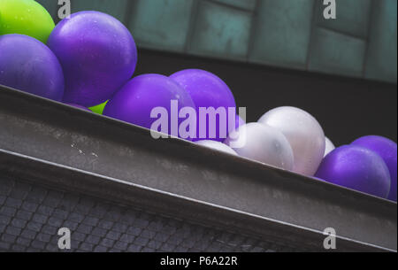 Violet, vert et blanc ballons sur le toit sous la pluie Banque D'Images