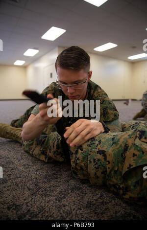 Le Sgt. Marcus Dean, un administrateur système de données avec le Siège Regiment, 3e Groupe logistique maritime, s'applique un garrot au cours de l'Examen de compétences en combat, le 21 juin 2018, au Camp Kinser, Okinawa, Japon. Au cours de la CEST, marines sont testés sur des compétences différentes telles que l'exploitation d'une radio, l'application des garrots et traitement des détenus. Dean est un natif de Vermilion, dans l'Ohio. (U.S. Marine Corps photo de la FPC. Terry Wong) Banque D'Images