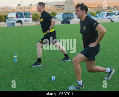 Secrétaire de l'armée, le Dr Mark T. Esper et U.S. Army Cpt. Jill King, chef de la 49e compagnie de théâtre Gateway, effectuer l'exercice sur une jambe arrière pendant la préparation physique avec le secrétaire de l'armée, le Dr Mark T. Esper au Camp Arifjan, au Koweït avec les soldats de la 49e compagnie de théâtre Gateway, le 21 juin 2018. Esper encourage les soldats à maintenir leur forme physique afin qu'ils soient toujours prêts à se battre.(U.S. Photo de l'armée par le Sgt. Fatima Konteh) Banque D'Images