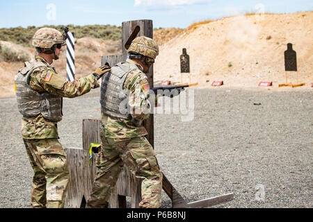 Le Sgt. Mark Jeffs avec la Compagnie Alpha, 1er Bataillon, 161e Régiment d'infanterie, 81e Stryker Brigade Combat Team indique à la CPS. Kristofer Cazimero au cours de formation au tir à courte portée au centre de formation de Yakima, Yakima, Washington, 21 juin 2018. Formation au tir à courte portée aide les soldats à augmenter leur précision dans les situations de combat urbain. (U.S. Photo de la Garde nationale par la CPS. Alec Dionne) Banque D'Images