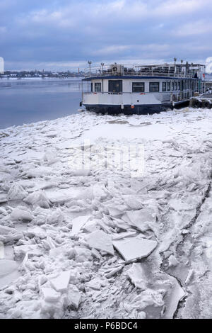 L'ancien bateau à vapeur à l'embarcadère, la glace brisée de la Daugava par une journée d'hiver Banque D'Images