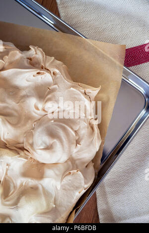 La cuisine de base de meringue pour une Pavlova dessert. La meringue fraîche, avec du haut d'or, sur le papier sulfurisé et une plaque de cuisson en acier inoxydable Overhea Banque D'Images