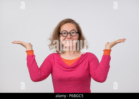 Happy woman in pink polo et lunettes cercle drôle posant avec les mains. Geek femelle est surpris avec des ventes ou des progrès au travail Banque D'Images