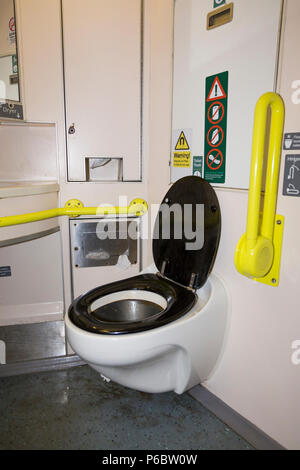 toilettes/toilettes ferroviaires - avec sol humide et qui est utilisé et un peu sale - avec accès handicapés et bars, et évier de bassin sur le train britannique près de SW London. ROYAUME-UNI. Banque D'Images