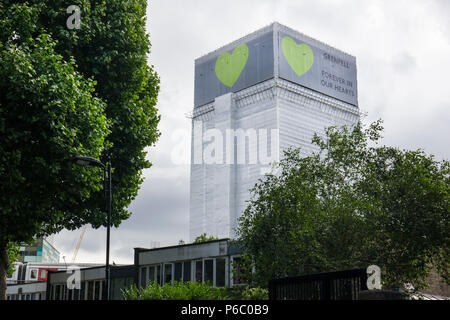 Le premier anniversaire de la tour de 24 étages de Grenfell bloc appartements de logement public qui a fait l'incendie 72 vit. Les shell a maintenant été recouverte d'une bâche blanche avec le message 'Grenfell pour toujours dans nos coeurs' South Kensington, Londres, Royaume-Uni, le 14 juin 2018. Banque D'Images