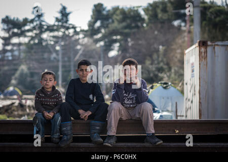 Les enfants réfugiés se trouve à la voie ferroviaire à la gare au camp de fortune du Greek-Macedonian frontière près du village grec de Idomeni. Banque D'Images