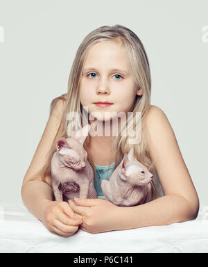 Jeune fille et sphinx chatons. Enfant avec Animaux acceptés Banque D'Images