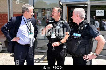 Damian Hinds (à gauche), député conservateur de East Hampshire , en conversation avec des policiers lors d'une visite dans une école pour ouvrir un nouveau réfectoire, Alton. Banque D'Images