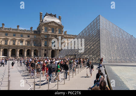 Les touristes l'attente dans la ligne en face de l'entrée au musée du Louvre Banque D'Images