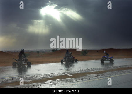 Dubaï, Émirats arabes unis, quad rider sous la pluie dans le désert Banque D'Images