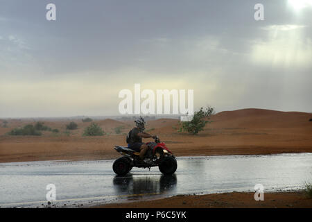 Dubaï, Émirats arabes unis, quad rider sous la pluie dans le désert Banque D'Images