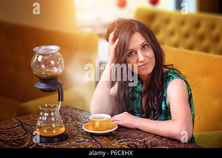 Femme dans un café est de boire le thé Banque D'Images
