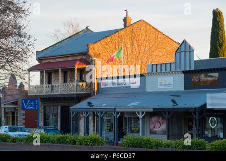 En regardant vers le sud le long de la rue principale (Old Hume Highway) à Mittagong que l'hiver soleil se lève sur la ville et réchauffe le côté d'une terrasse de style victorien. Banque D'Images