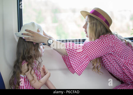 Mère et fille se déplace dans le train - woman wearing hat aide girl Banque D'Images