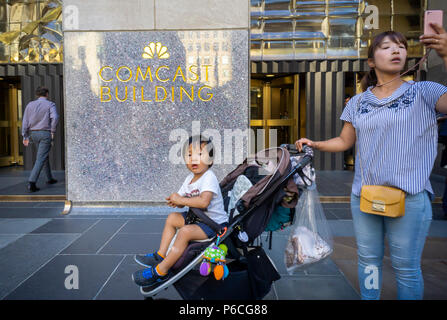 Les touristes à Rockefeller Plaza à New York passer le bâtiment de Comcast, le mardi 19 juin 2018. Les deux Comcast et Disney sont en concurrence pour l'achat de 21e siècle Fox. (Â© Richard B. Levine) Banque D'Images