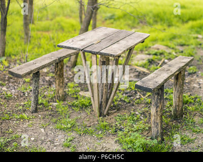 Table en bois en milieu rural et deux bancs dans la cour sur l'herbe Banque D'Images