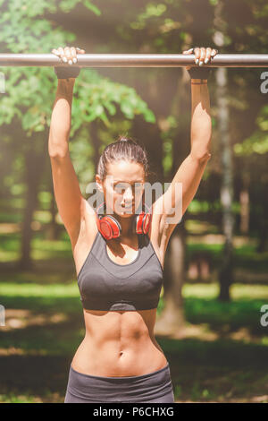 Femme Fitness la préparation pour faire pullups dans la nature. Concept de vie sain. Banque D'Images