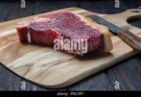 Sécher de T-bone steak matières sur une planche de bois. Banque D'Images